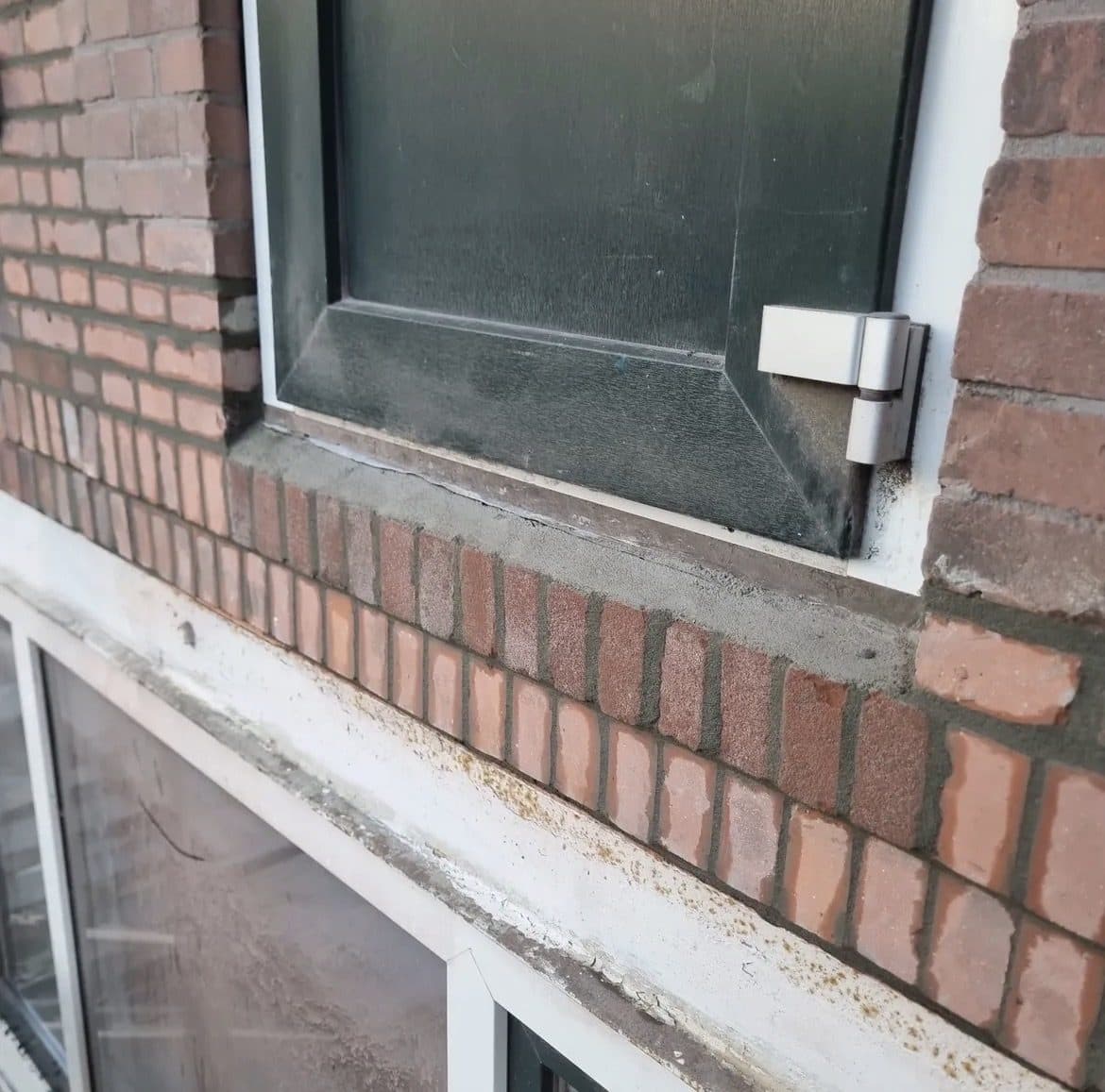 Detail van hersteld metselwerk en voegwerk rond een kozijn en onderdorpel