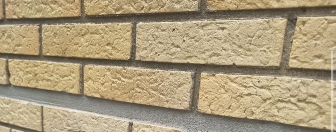 Close-up van voegwerk in geel getextureerd metselwerk