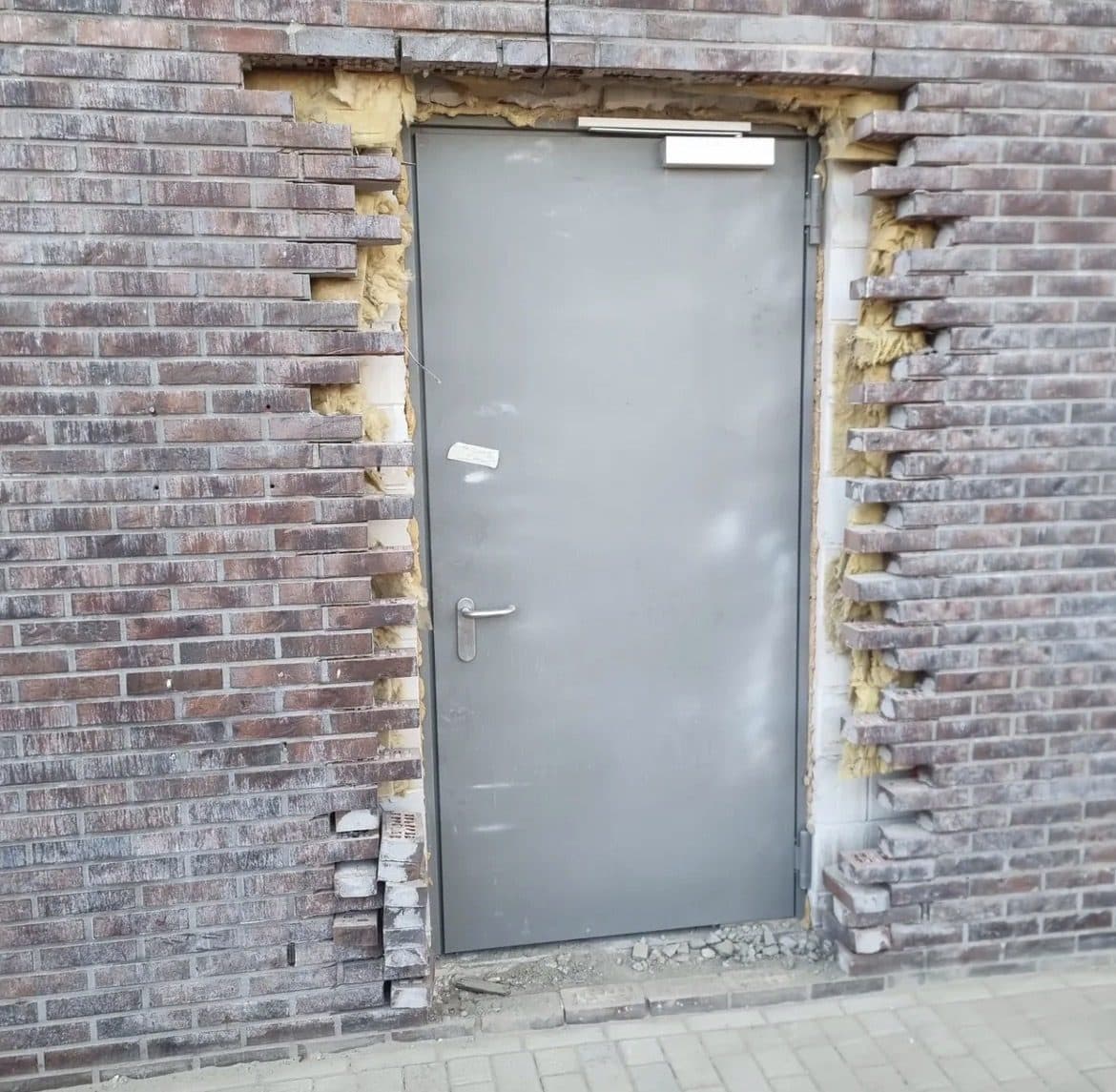 Close-up van de afgeronde aansluiting tussen metselwerk en deurkozijn